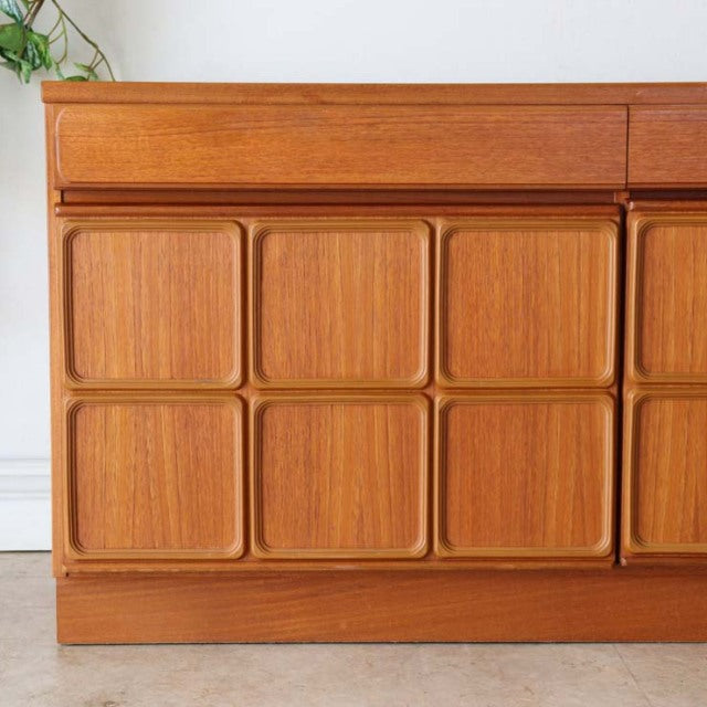Vintage British McIntosh teak sideboard with mid-century design, distinctive square recessed panel doors, smooth wood grain, .
