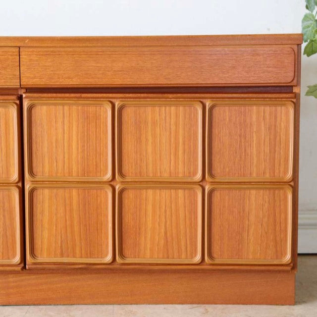 Mid-century British McIntosh vintage teak sideboard with textured square panel doors and smooth grain wood finish.