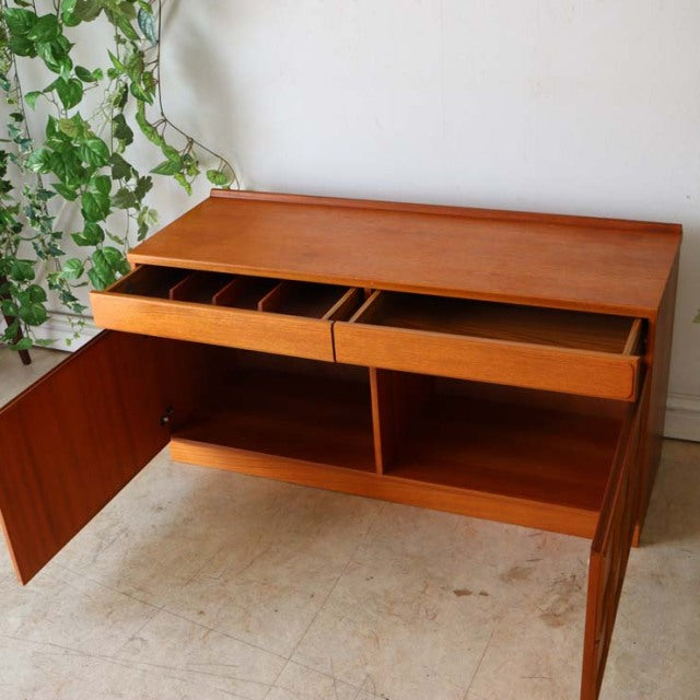 Vintage British McIntosh teak sideboard with rich wood grain, mid-century design, open top drawers, and double-door lower.