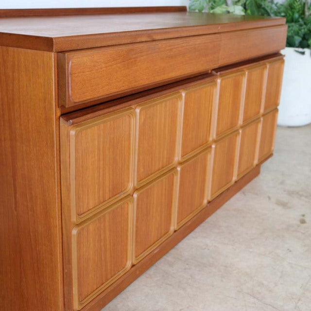 Vintage British mid-century teak sideboard by McIntosh featuring a rich wood grain and textured rectangular panel design on.
