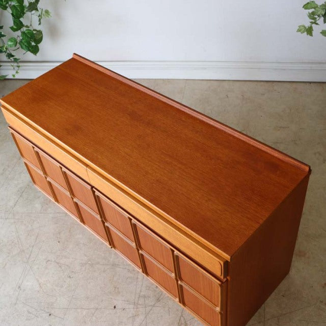 Vintage British mid-century teak McIntosh sideboard with rich wood grain, geometric panel front, and tapered legs.
