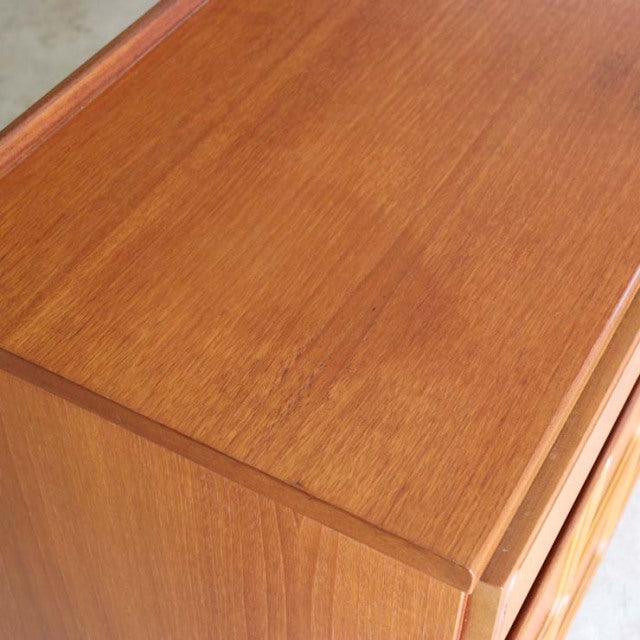 Mid-century British McIntosh teak sideboard top and corner showing smooth wood grain and clean edges.