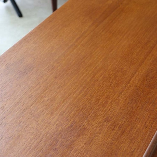 Close-up of vintage British McIntosh mid-century teak sideboard showcasing smooth wood grain and polished surface.