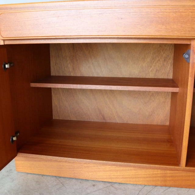 Interior view of British mid-century McIntosh teak sideboard showing smooth wood grain and adjustable shelf.
