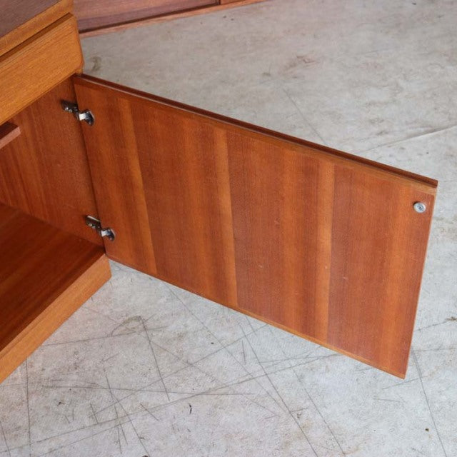 Mid-century British teak sideboard door open showing rich wood grain and clean, smooth finish.