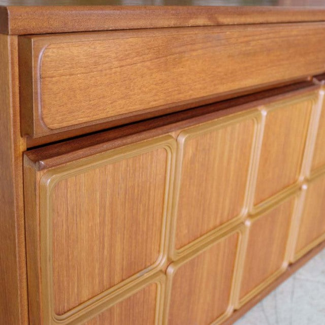 Vintage British McIntosh sideboard in teak with mid-century design, visible wood grain, and curved drawer fronts.