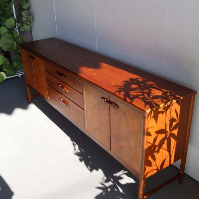 Vintage teak sideboard by Nathan with sleek mid-century British design, smooth wood grain, tapered legs, and integrated.