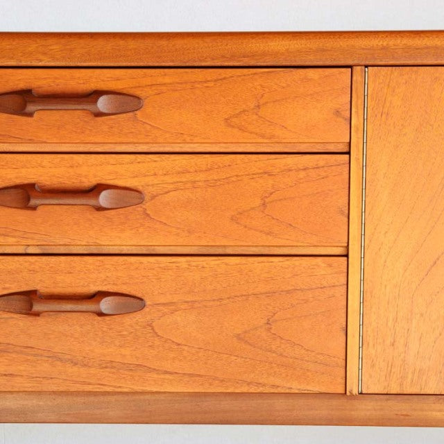 Vintage teak Nathan sideboard with smooth wood grain, mid-century British design, tapered legs, and unique carved drawer.