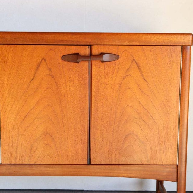 Vintage teak sideboard by British brand Nathan, mid-century design with smooth wood grain and rounded wooden handles,.