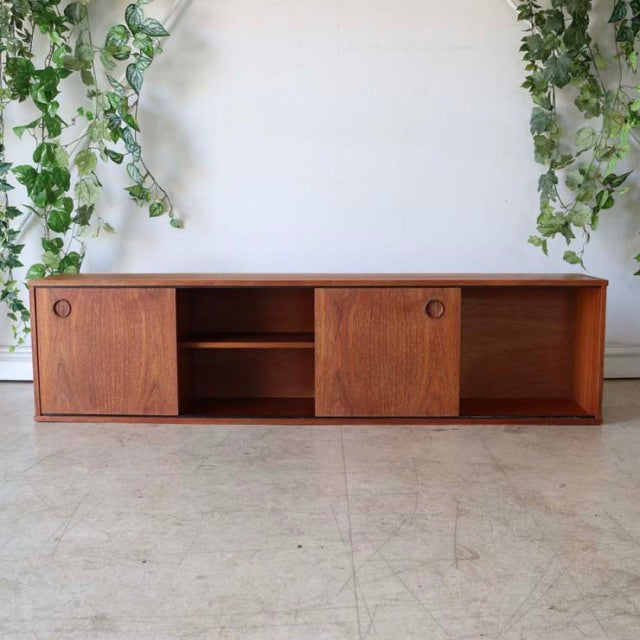 Vintage mid-century teak lowboard by AVALON with sliding doors, visible wood grain, and sleek low legs, showcasing British.