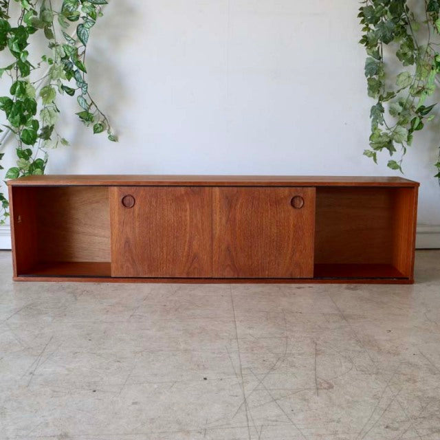 Mid-century British vintage teak lowboard by AVALON with sliding doors, rich wood grain, and rectangular form.