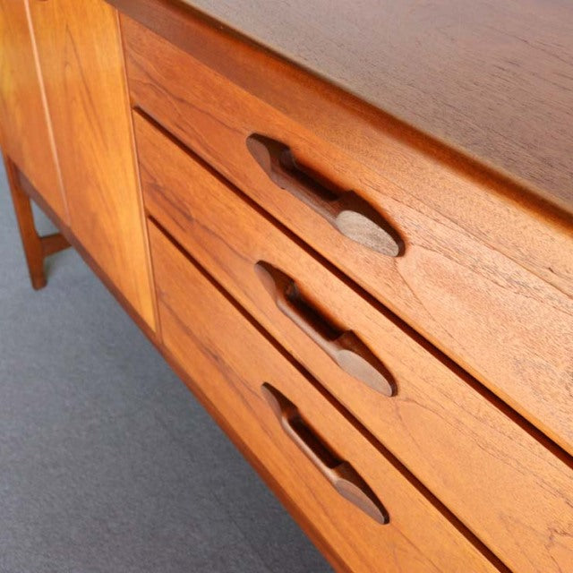 Vintage teak sideboard by Nathan, British mid-century design from Denmark, showing rich wood grain and sculpted drawer.