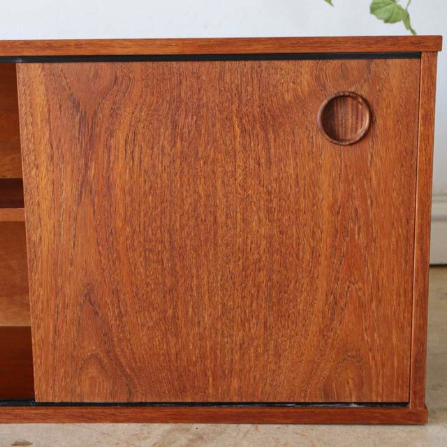 Vintage teak Avalon lowboard door panel showing rich wood grain and circular recessed handle, mid-century British Denmark.