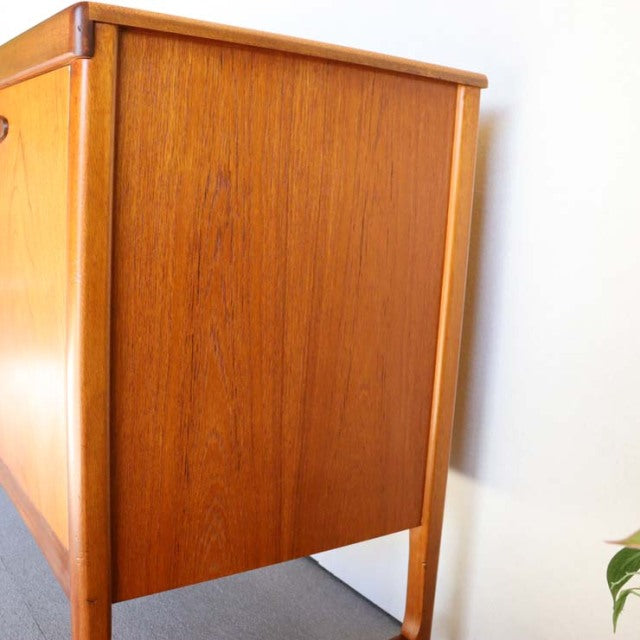 Mid-century vintage teak sideboard by Nathan with smooth wood grain, slim tapered legs, and clean British-Denmark design.