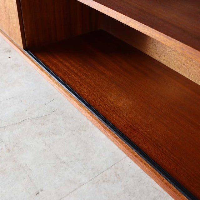 Vintage teak Avalon lowboard showcasing rich wood grain, mid-century British design, smooth sliding door track, and.