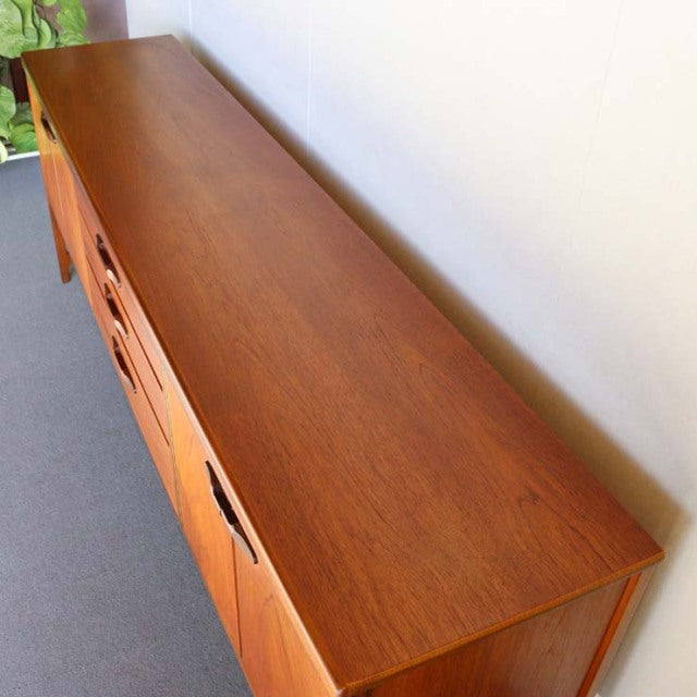Vintage teak sideboard by British brand Nathan, mid-century Danish style with smooth wood grain and tapered legs.