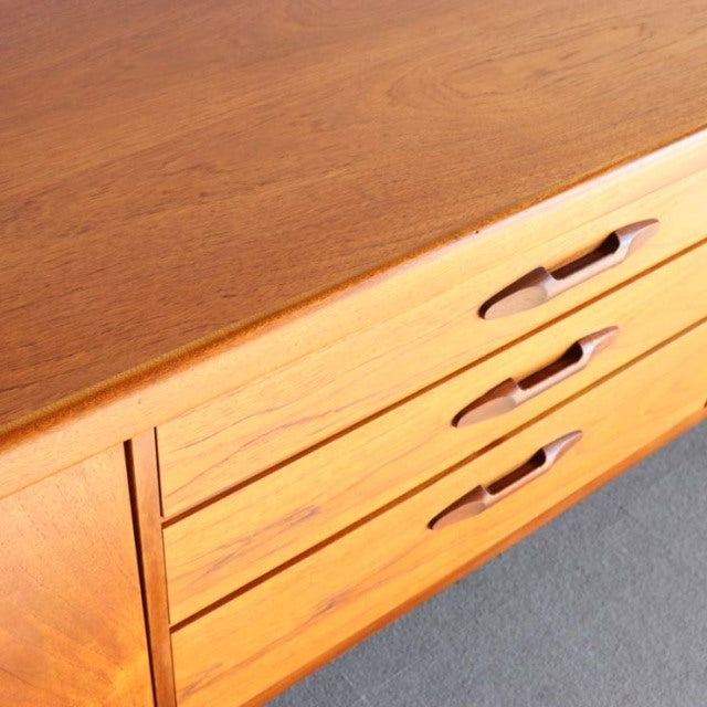 Mid-century British teak sideboard by Nathan, featuring smooth wood grain and integrated recessed handles.