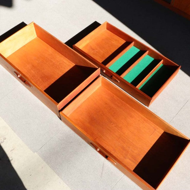 Mid-century British Nathan teak sideboard drawers featuring rich wood grain and green felt-lined compartments, showing clean .