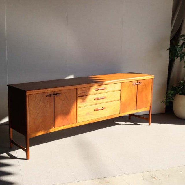 Vintage Nathan teak sideboard from mid-century British-Danish design, showcasing warm wood grain, tapered legs, and sleek.
