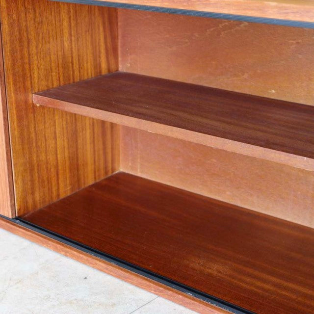 Vintage British mid-century teak lowboard interior showing rich wood grain and smooth shelves.