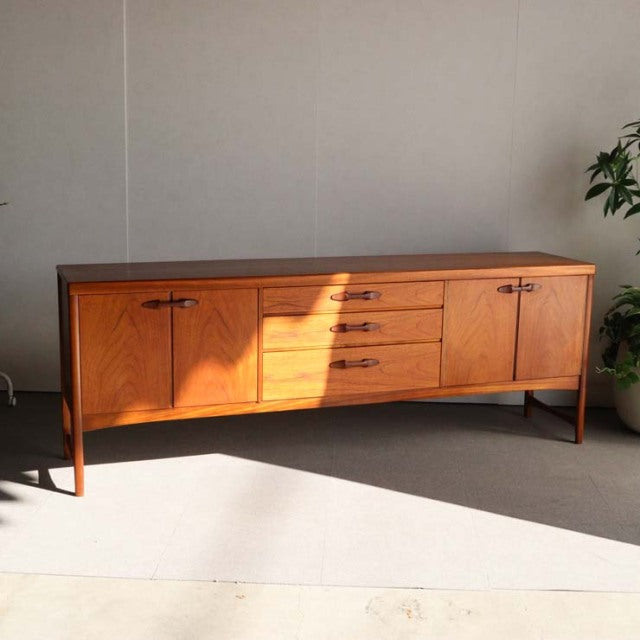 Mid-century British Nathan teak sideboard with rich wood grain, tapered legs, and sleek drawer and door fronts.