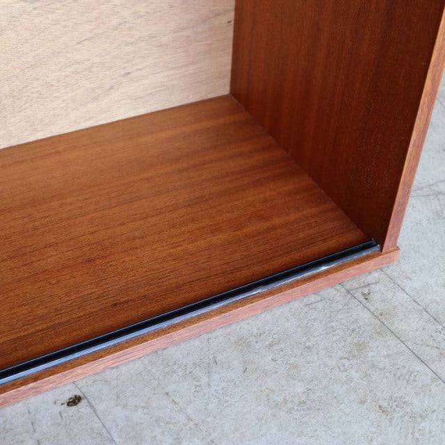 Close-up of vintage teak wood grain and corner detail on mid-century British Avalon low board, showcasing smooth finish and.