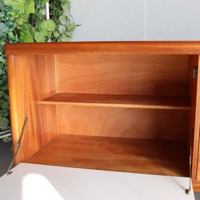 Open teak sideboard by British brand Nathan showcasing clean mid-century lines and visible wood grain with side panels held.