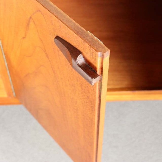 Vintage teak sideboard door corner showing rich wood grain, British mid-century design by Nathan, Danish influence, smooth.