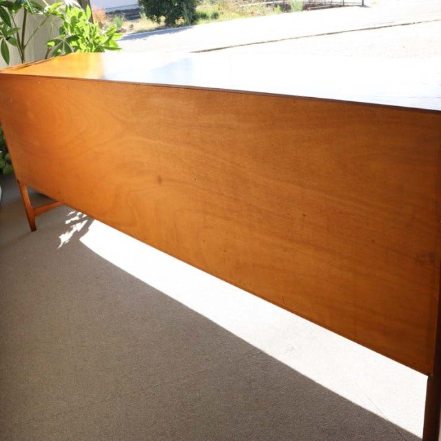 Vintage teak sideboard by British brand Nathan, mid-century Danish design with smooth wood grain and tapered legs.