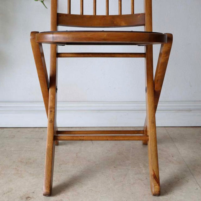 Vintage British mid-century teak folding chair with slender legs and visible wood grain.