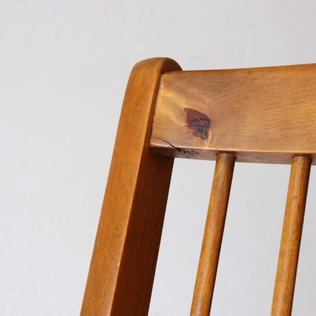 Vintage British mid-century teak folding chair backrest with warm wood grain and spindle detail.