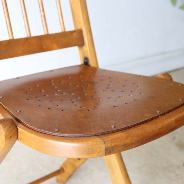 Vintage teak mid-century British folding chair with visible wood grain and spindle backrest.