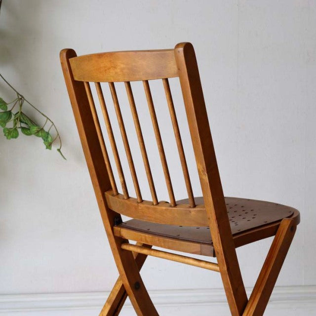 Vintage British teak folding chair with vertical slat backrest and perforated seat, mid-century design.