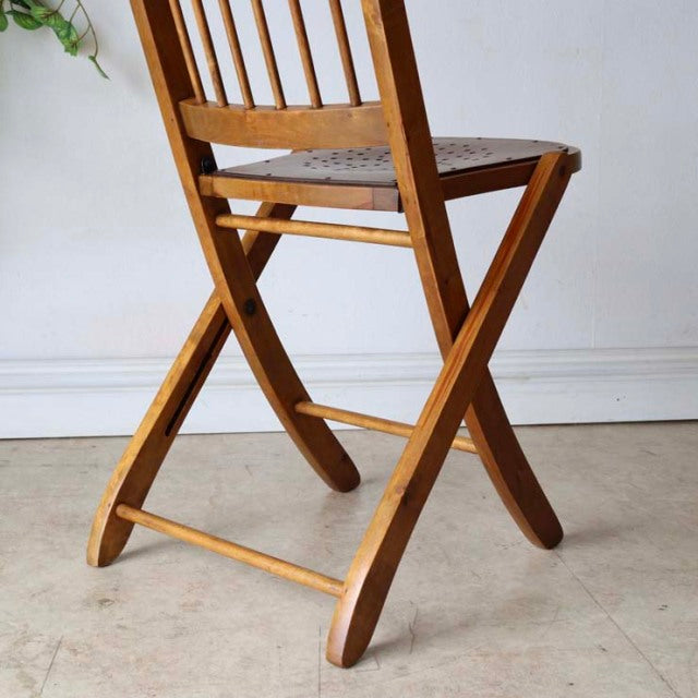 Set of two vintage mid-century British teak folding chairs with slatted backs and visible wood grain.