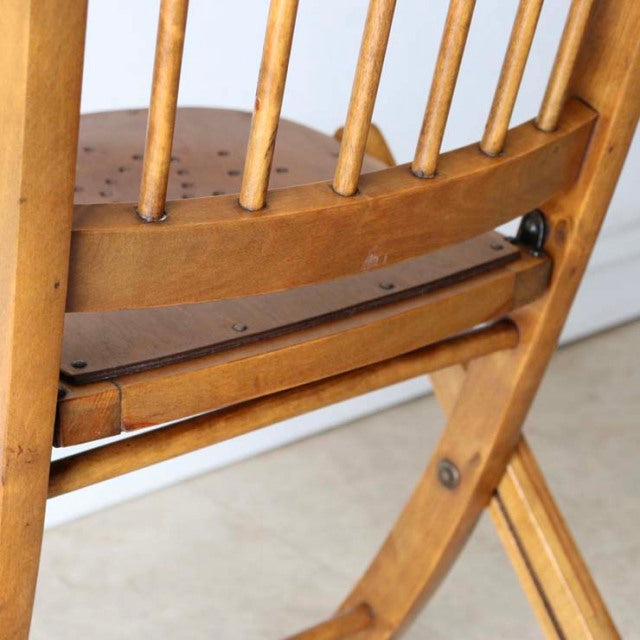 Vintage teak folding British chair with spindled backrest and visible wood grain finish.