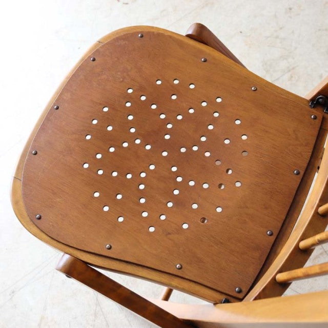 Vintage British mid-century teak folding chair seat with decorative perforated pattern and visible wood grain.