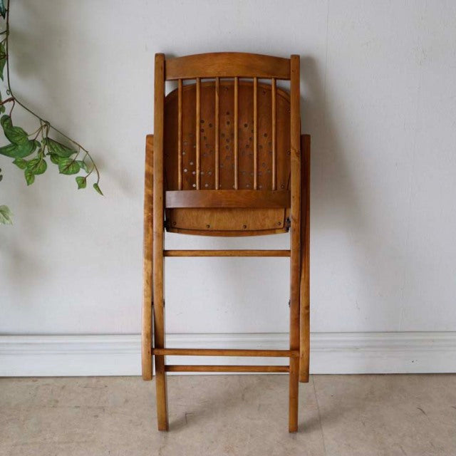 Vintage British mid-century teak folding chair with vertical slatted backrest and natural wood grain.
