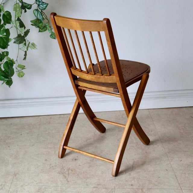 Vintage British mid-century teak folding chair with vertical slat back and curved legs.