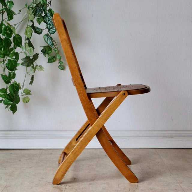 Vintage British mid-century teak folding chair with curved legs and visible wood grain.