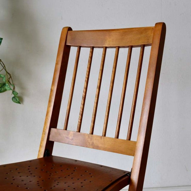 Set of two vintage British mid-century teak folding chairs with slatted backs and perforated seats, showcasing warm wood.