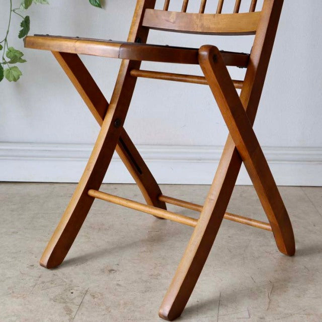 Vintage British mid-century teak folding chair with warm wood grain and slatted backrest.