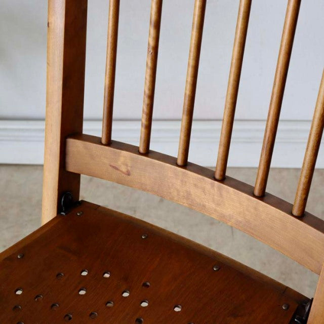 Mid-century British vintage teak folding chair with curved backrest and spindle slats showing rich wood grain.