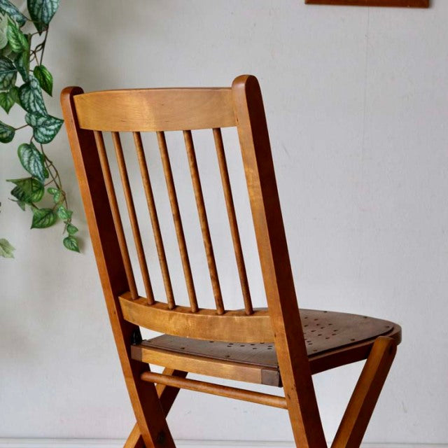 Vintage British mid-century teak folding chair with slatted backrest and sturdy legs, showcasing natural wood grain.