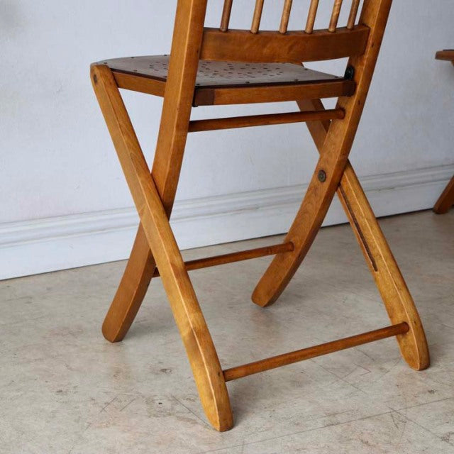 Mid-century British vintage teak folding chair with visible wood grain and simple slatted back, showcasing clean lines and.