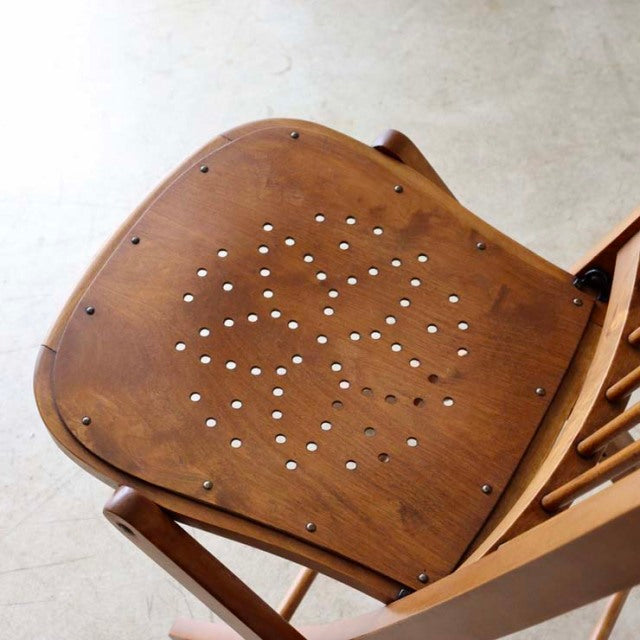 Set of two vintage British mid-century teak folding chairs with perforated seat design and sturdy angled legs.