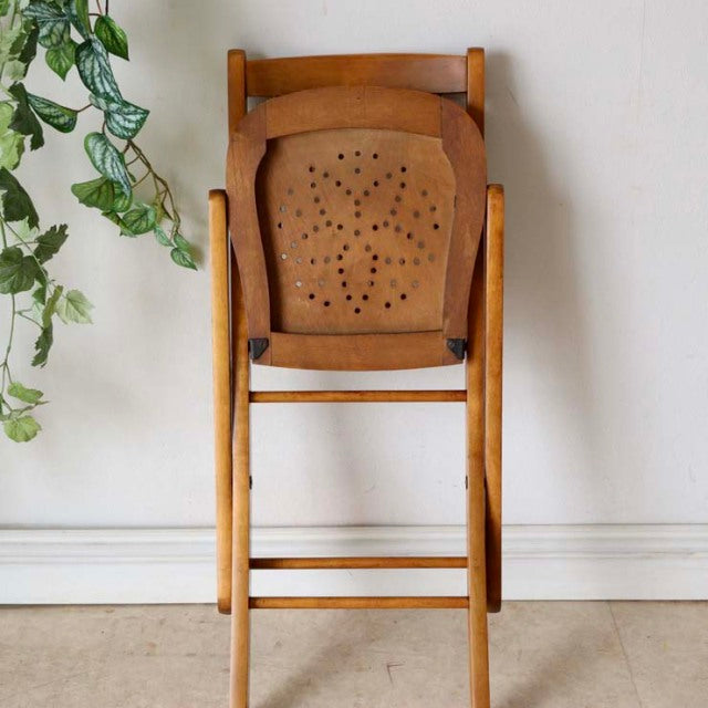 Vintage teak folding chair with perforated backrest, mid-century British design, sturdy wooden frame.