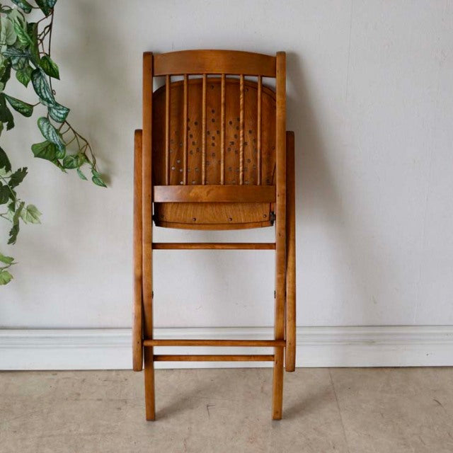 Vintage British teak folding chair with mid-century slatted back and visible wood grain, Denmark style.