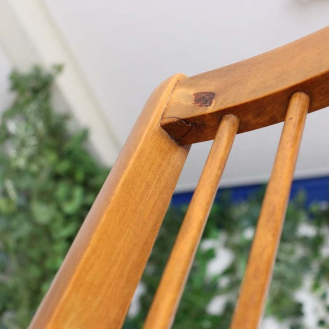 Vintage British teak folding chair with slender spindle backrest and warm wood grain finish, mid-century style from Denmark.