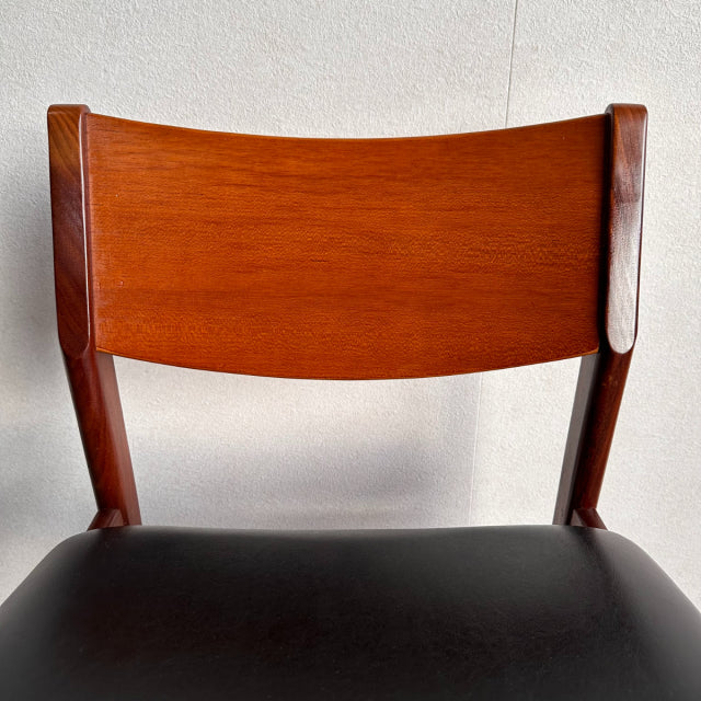 Vintage British mid-century dining chair with rich teak wood backrest and black leather seat.