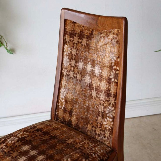 Set of four vintage British mid-century G-Plan dining chairs in teak with patterned fabric upholstery and tapered wooden legs.